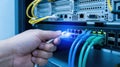 Technicians Hand Plugging in an Ethernet Cable into a Network Switch in a Server Room Royalty Free Stock Photo