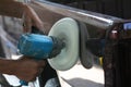 Automotive paint technician using grinder machine with wax on side of pickup , A part of the procedure to make a new color car