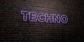 TECHNO -Realistic Neon Sign on Brick Wall background - 3D rendered royalty free stock image