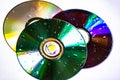 Technological background created with the photo of three wet CDs, the light accentuates the reflections coloring them.