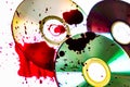 Technological background created with the photo of three wet CDs, the light accentuates the reflections coloring them. Royalty Free Stock Photo