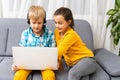 Technology, bkids friendship and communication concept - two cute teenagers using tablet and laptop while sitting on the Royalty Free Stock Photo