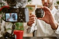 Technology blog. Close up photo of blogger`s hands showing camera lens online and speaking about its advantages