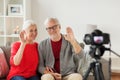 Happy senior couple with camera recording video