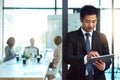 Technology can help your business, use it. a handsome young businessman using a tablet in the workplace. Royalty Free Stock Photo