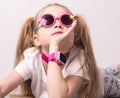 Technology for children: a girl wearing pink glasses uses a smartwatch