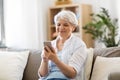 Happy senior woman with smartphone at home Royalty Free Stock Photo