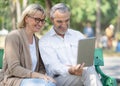 Technology connect and modern lifestyles concept. Aged senior couple waving hands greeting grandkids via facetime video Royalty Free Stock Photo