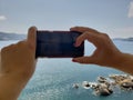 hands of a woman taking a picture with a smartphone in a place of tropical climate