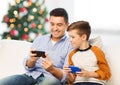 Happy father and son with smartphones at christmas Royalty Free Stock Photo