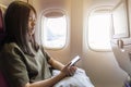 Technology on flight traveling or flying on plane with young girl passenger or woman traveller using mobile smartphone, online app