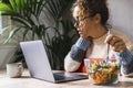 Technology and food concept image with one woman too busy at job eating healthy salads while work on computer. Lunch break during Royalty Free Stock Photo