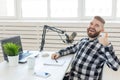 Technology, home, music and lifestyle concept - smiling man with laptop and headphones at home showing thumbs up Royalty Free Stock Photo