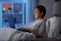 woman with laptop in bed at home at night Royalty Free Stock Photo