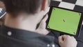 Technology and internet concept, over the shoulder view of a man tapping on the green screen of a tablet with tracking Royalty Free Stock Photo