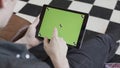 Technology and internet concept, over the shoulder view of a man tapping on the green screen of a tablet with tracking Royalty Free Stock Photo