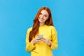 Technology, internet and gadgets concept. Cute redhead woman sending text friend, messaging, having conversation using