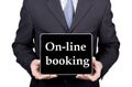 Technology, internet and networking in tourism concept - businessman holding a tablet pc with on-line booking sign