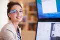 Technology just got smarter. Portrait of a young woman wearing smart glasses while working on a dual-screen computer.