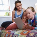 Technology keeping them entertained. a group of teenage friends using a digital tablet together. Royalty Free Stock Photo