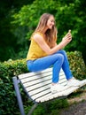 Technology keeps her in the social loop. a young woman relaxing in the park.