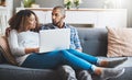 Technology keeps modern couples connected. a young couple relaxing on the sofa at home and using a laptop together. Royalty Free Stock Photo