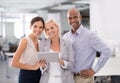 Technology keeps them connected. a businesswoman holding a digital tablet surrounded by her colleagues.