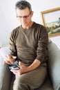 technology, lifestyle and communication concept - senior man dialing phone number and texting on smartphone at home Royalty Free Stock Photo