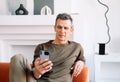 technology, lifestyle and communication concept - senior man dialing phone number and texting on smartphone at home Royalty Free Stock Photo