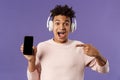 Technology and lifestyle concept. Portrait of excited impressed young man in headphones listening music, online platform