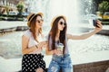 Technology, lifestyle and people concept - happy young two friends women taking selfie by smartphone and drinking cocktails drinks Royalty Free Stock Photo