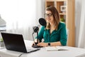 Woman with microphone recording podcast at studio Royalty Free Stock Photo