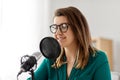 Woman with microphone recording podcast at studio Royalty Free Stock Photo