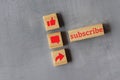 Top view of wooden cubes with text SUBSCRIBE and like, comment and share icon