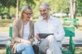 Technology and modern elderly lifestyles concept. Aged senior couple waving hands greeting grandkids via facetime video Royalty Free Stock Photo