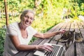 Happy senior old woman with home cat working online with laptop computer outdoor Royalty Free Stock Photo