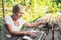 Happy senior old woman with home cat working online with laptop computer outdoor Royalty Free Stock Photo