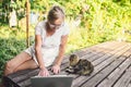 Happy senior old woman with home cat working online with laptop computer outdoor Royalty Free Stock Photo