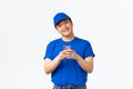 Technology, online shopping and shipping concept. Cheerful smiling asian courier in blue uniform, tracking shipment