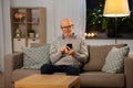 Happy senior man texting on smartphone at home Royalty Free Stock Photo