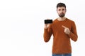Technology, people and communication concept. Portrait of upset and disappointed, gloomy bearded caucasian man pointing