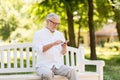 Senior man with smartphone at summer park Royalty Free Stock Photo