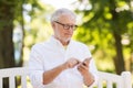 Senior man with smartphone at summer park Royalty Free Stock Photo