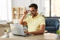 Indian man with laptop working at home office