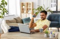 Man with laptop and hand expander at home office Royalty Free Stock Photo