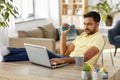 Man with laptop and hand expander at home office Royalty Free Stock Photo