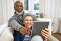 Technology, senior couple with tablet and on sofa happy in living room of their home. Social media or streaming Royalty Free Stock Photo