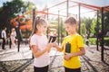 Technology and sport for children. Two teenage kids using smartphone and online workout app. Twins boy and girl watching video on