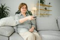 technology, television, age and people concept - happy senior woman watching tv and changing channel with remote control Royalty Free Stock Photo