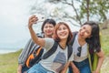 Technology, travel, tourism, jungle hike and people concept - group of smiling friends with backpacks taking selfie by smartphone Royalty Free Stock Photo